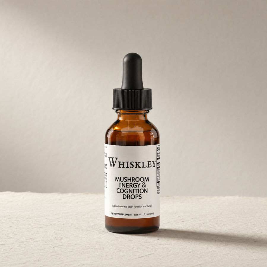Whiskley Mushroom Energy Cognition Drops amber glass dropper bottle standing on textured washi paper in warm side-light